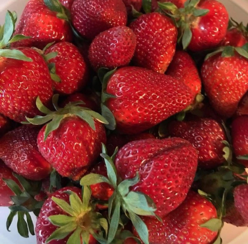 A close-up of ripe red strawberries with green caps