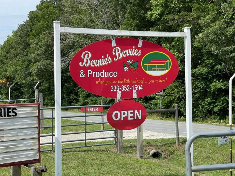 The red Bernie's Berries & Produce sign with the OPEN sign hanging below
